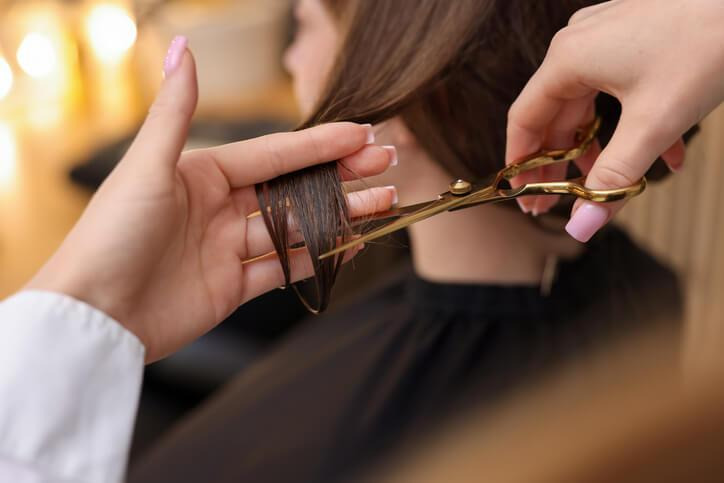 A cosmetology student practicing professional hairstyling techniques