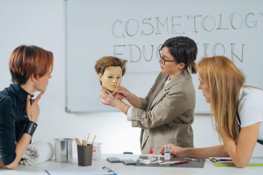A cosmetology instructor demonstrating salon techniques during practical training
