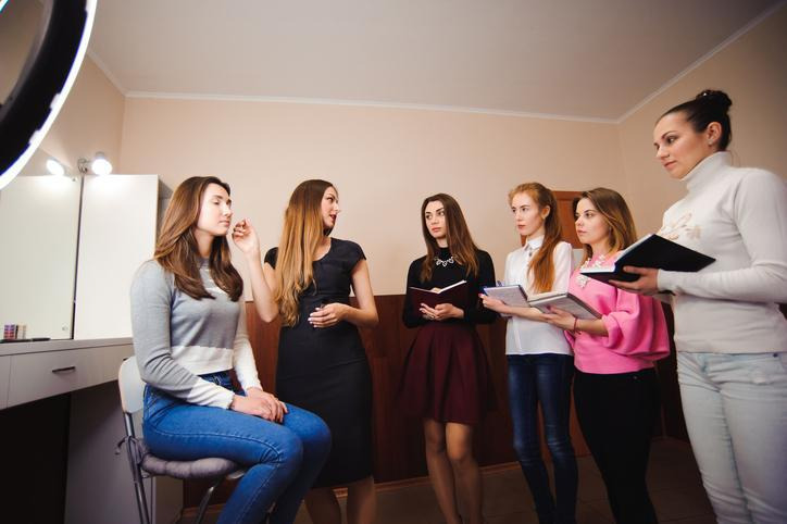 Beauty instructor teaching cosmetology students professional styling skills